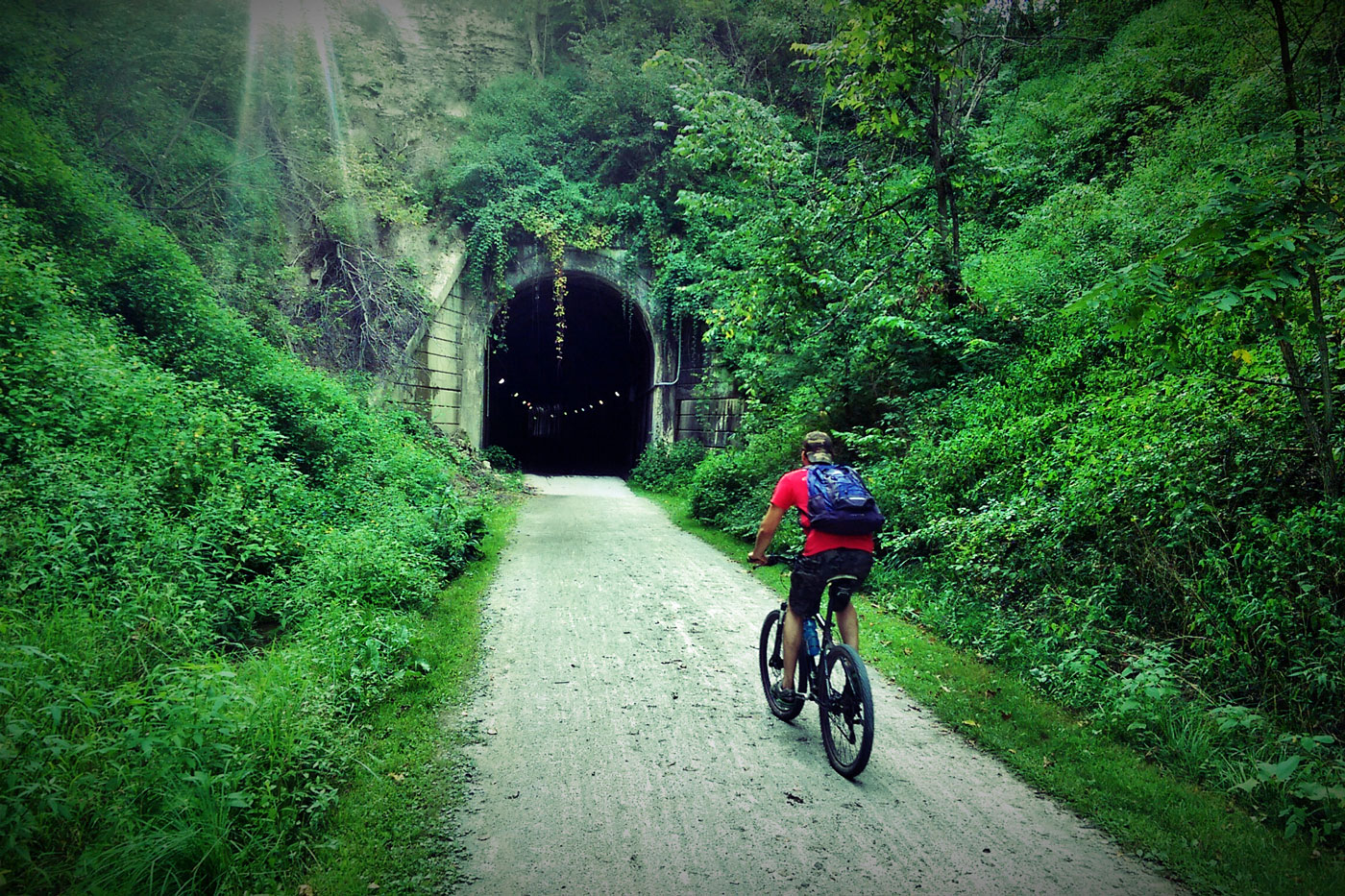 a person on bike riding Infront of a tunnel