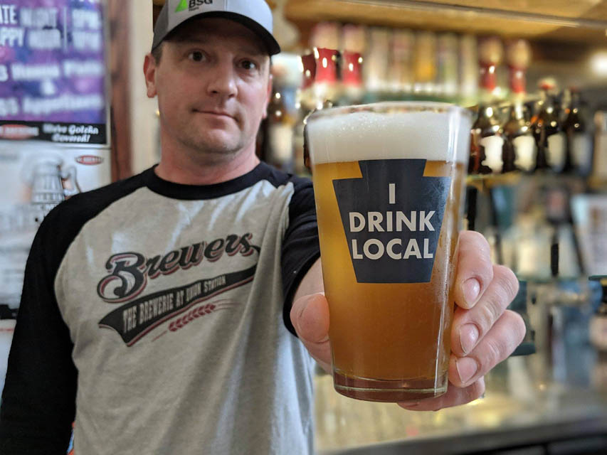 person holding a pint glass beer