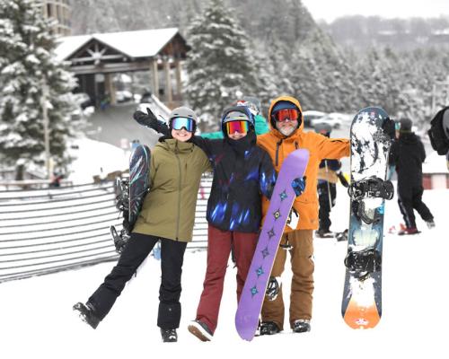 family posing with snow boards