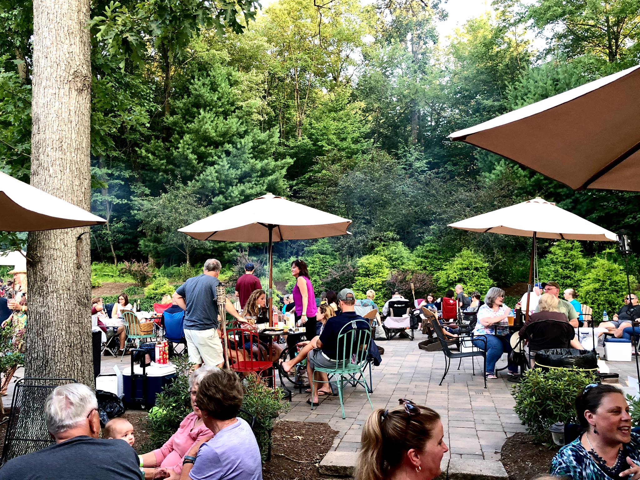 A photo of an outdoor patio filled with people enjoying wine under umbrellas at Seven Mountain Wine Cellars in Pennsylvania