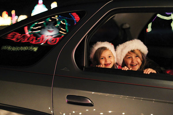 kids watching holiday lights from car