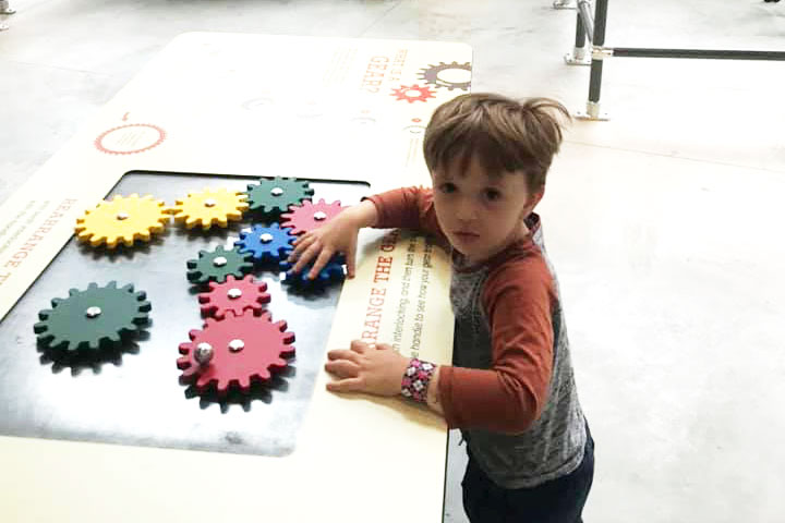 kid playing with gears at museum