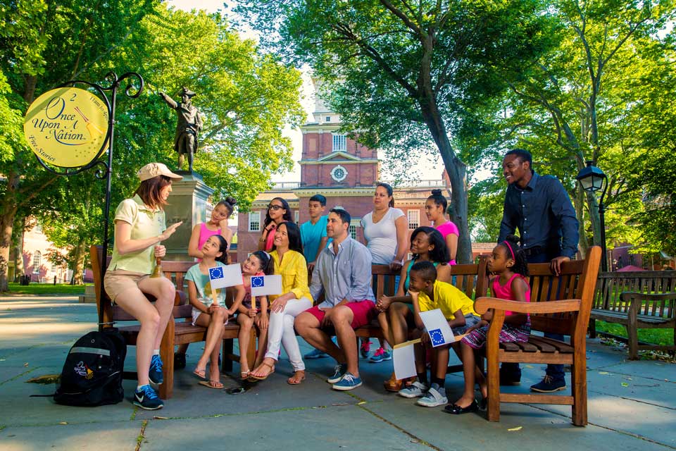 group of people sitting on a bench in yard