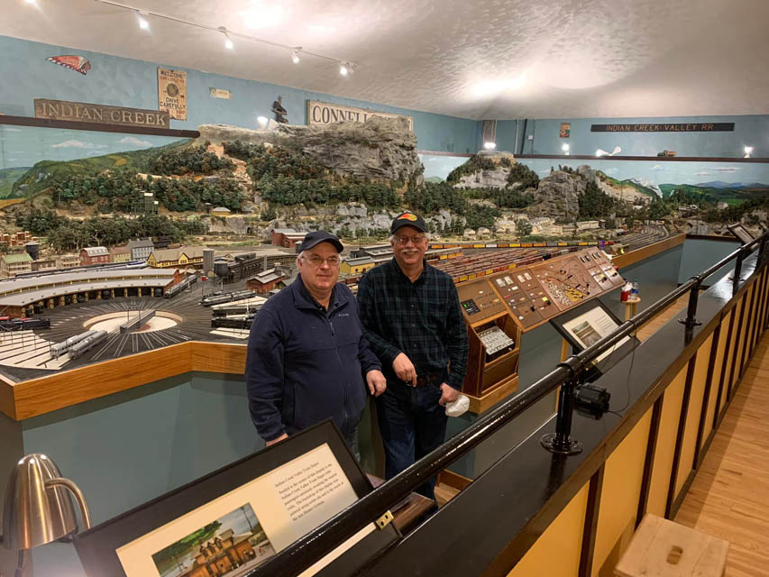 two person standing next to train display