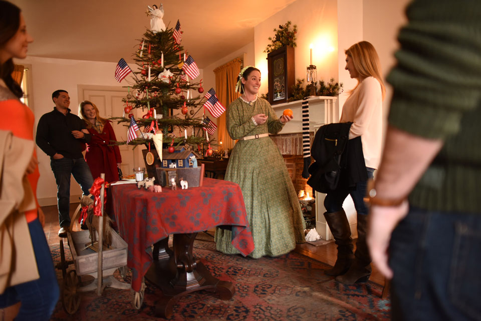 A group of people around a table with Christmas Tree