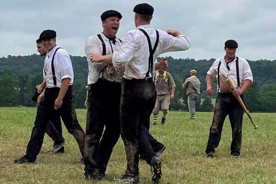 people playing baseball dressed as if in nineteenth century