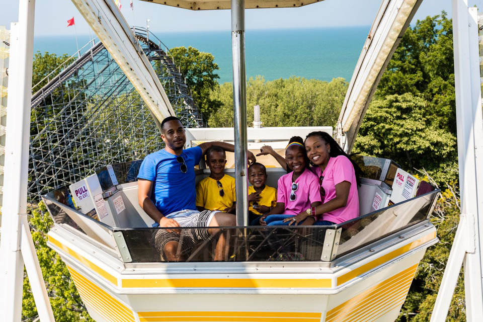 a family posing for photo enjoying a ferris wheel