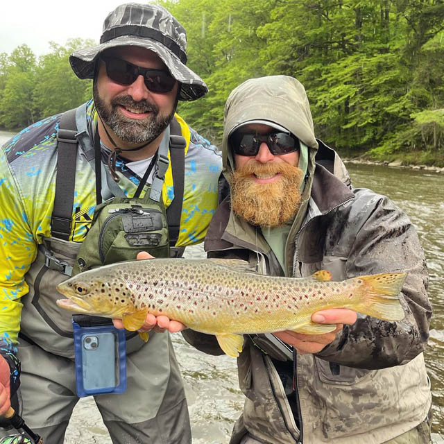 two persons posing with a trout caught