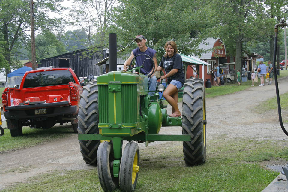 a couple driving steam engine tractor