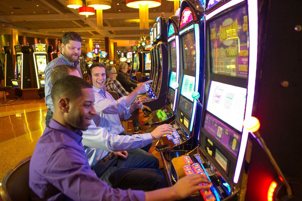 group of men playing slot machine at mount airy casino resort