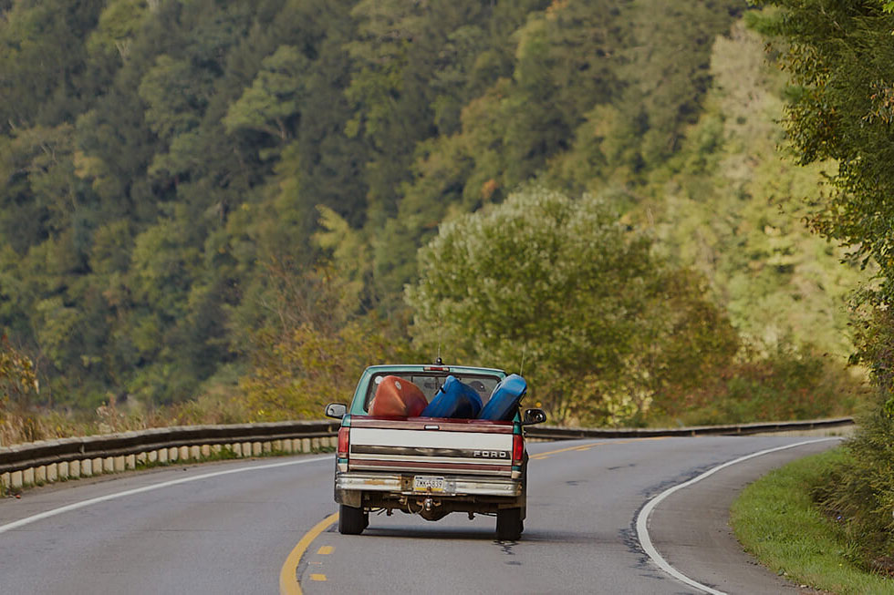 a truck carrying kayaks in the trunk