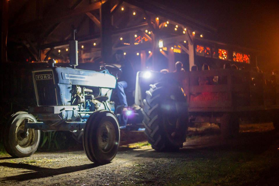 a tractor wagon carrying people at night