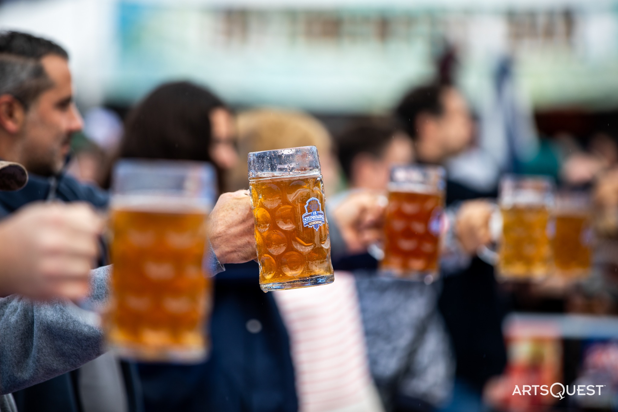 People holding beer mugs lined up