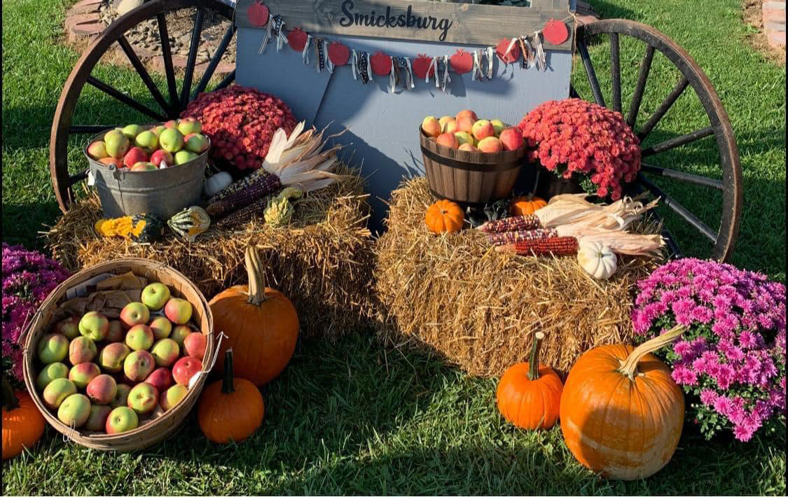Apple and Pumpkins in Baskets placed on Hay Stacks