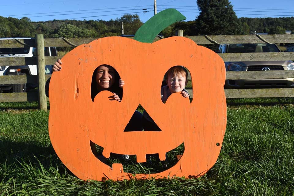 mother son posing for a photo with pumpkin