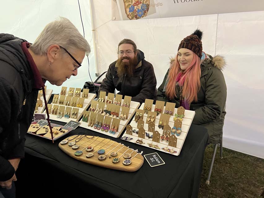 a women looking at hand crafted ornaments in Holiday market
