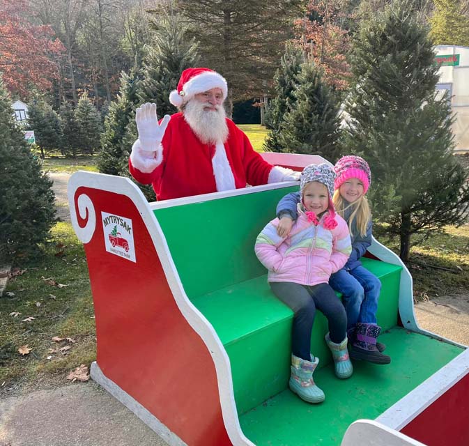 kids taking photo with Santa sleigh