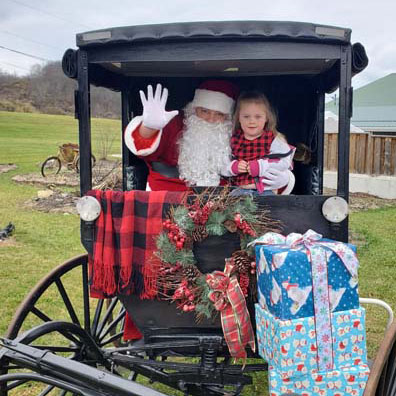 little girl along with Santa on a horse carriage ride