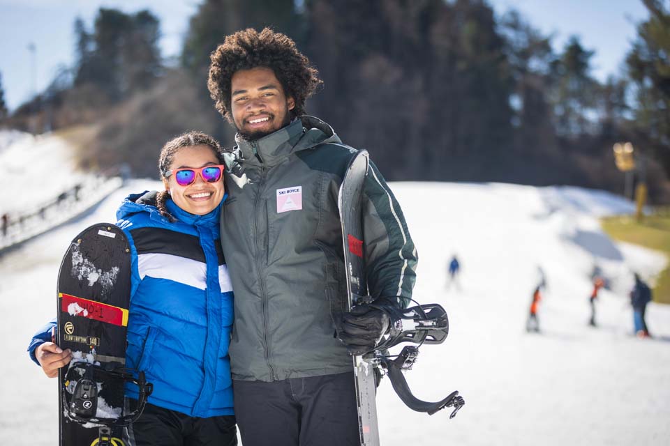 couple posing with their skiboards