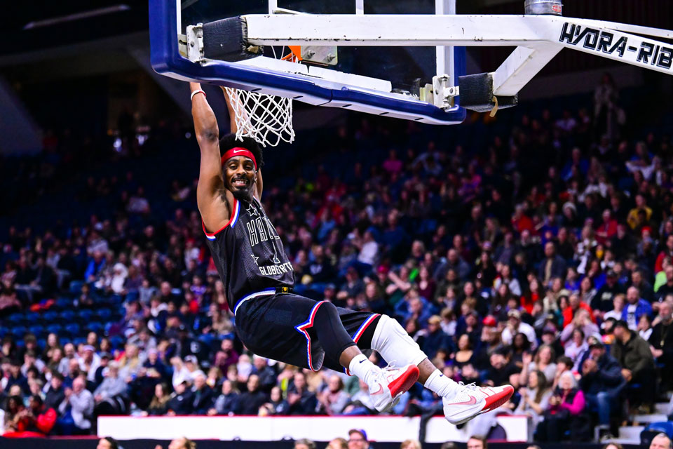 basketball player hanging on to basket net