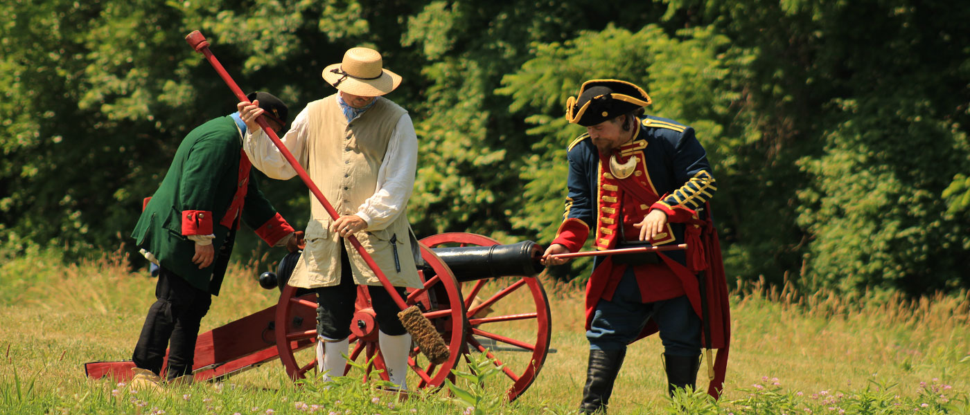a group of men prepping a cannon to fire