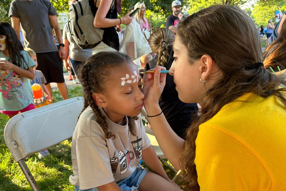 a little girl getting face painting at Carlisle summer fair