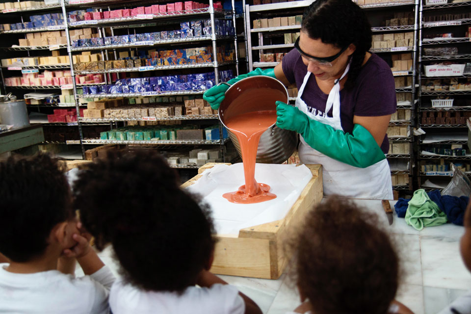 a women demonstrating soap making to group of kids