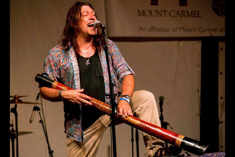 an artist singing and holding an instrument