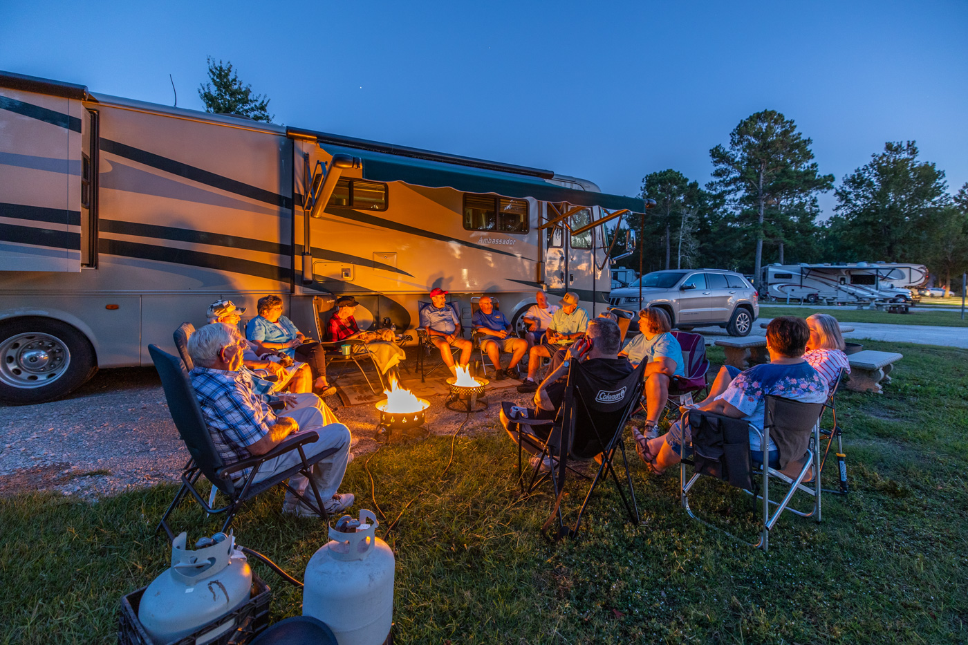 Group of campers enjoying campfire by RV at Goddard Park VacationLand Campground