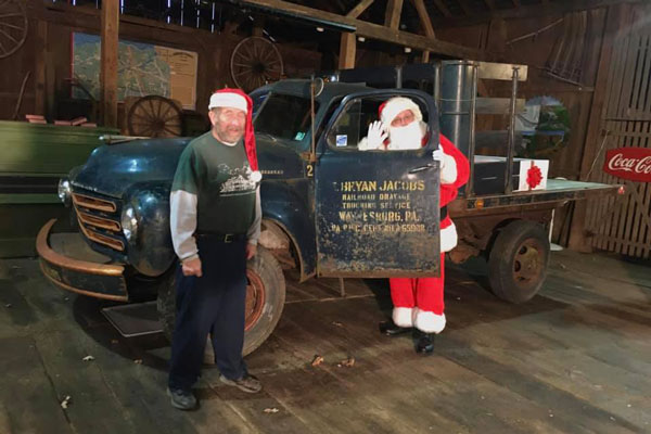 guy dressed as Santa standing behind truck door other standing next to truck