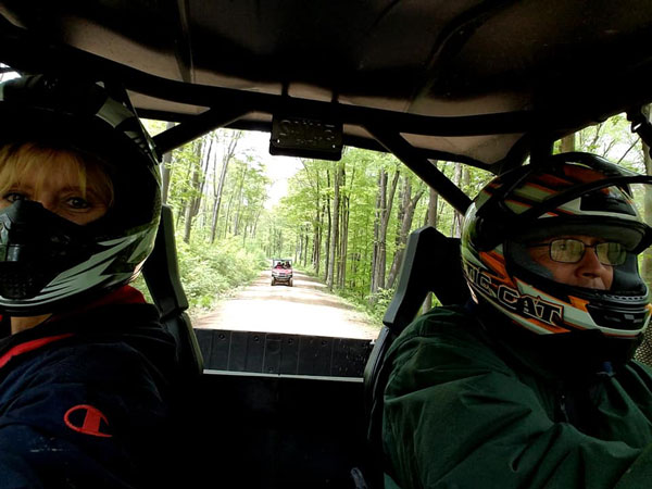 couple riding ATV with gear on 