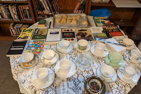 books empty tea cups and desserts on table