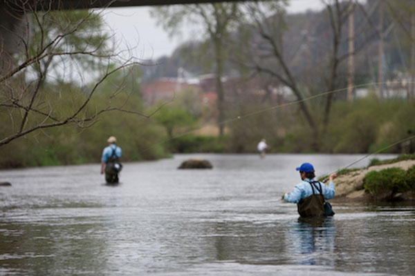 A Person fishing standing in Allegheny River deep neck