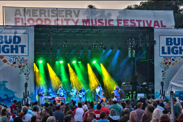 Band playing on stage with lights and Audience around 