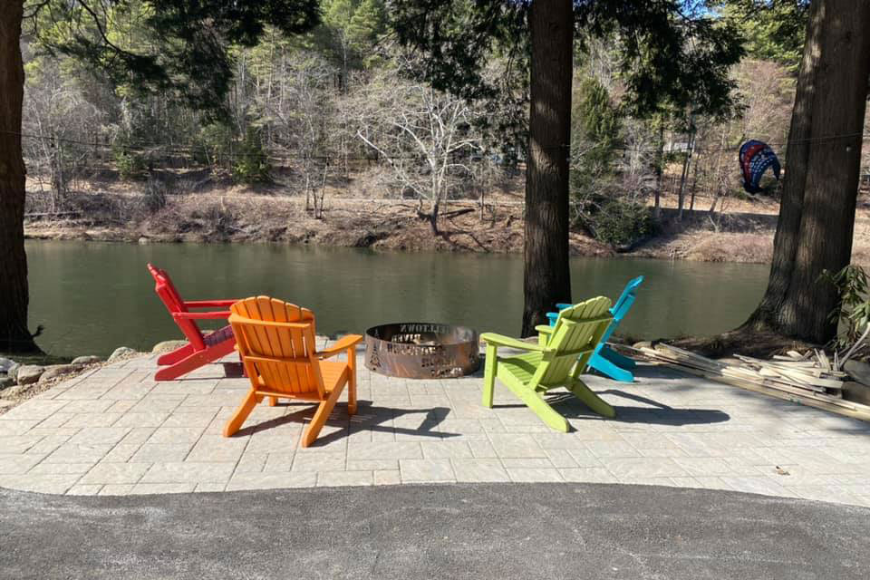 camping chairs around campfire by lake