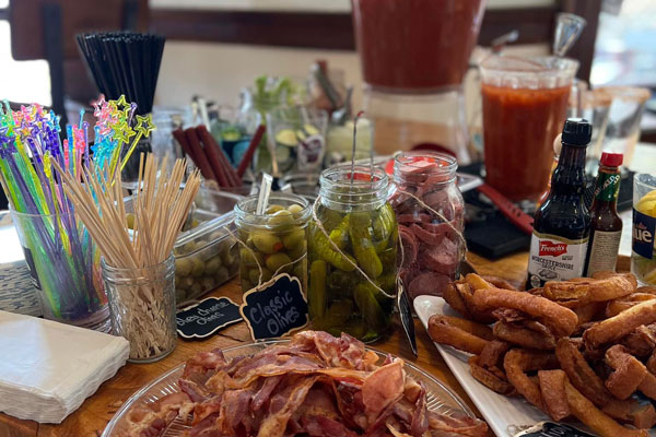 bacon fries drinks and pickled jars on table