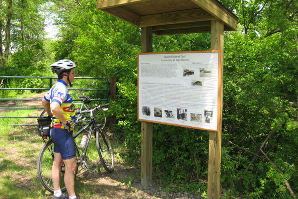 Biker looking at trail board signage