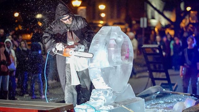 a person carving ice sculptor on street