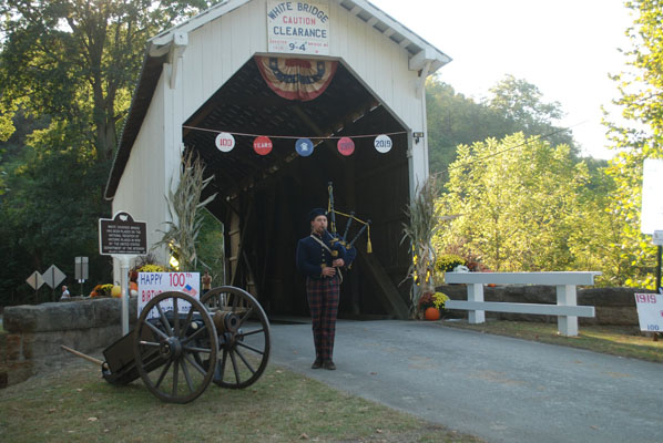 bag piper infront of covered bridge