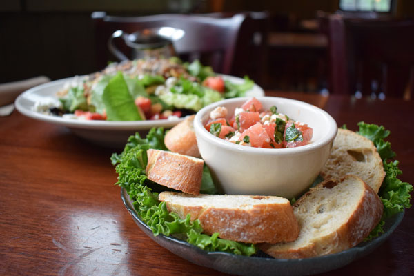 Salad in a plate and toast on other side 