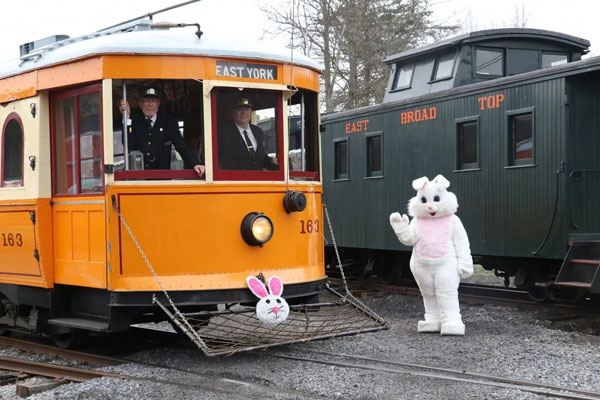 Easter bunny disguise standing next to train wagons with TC standing infront