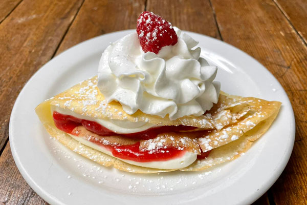 crepe with whipp cream and strawberry on top