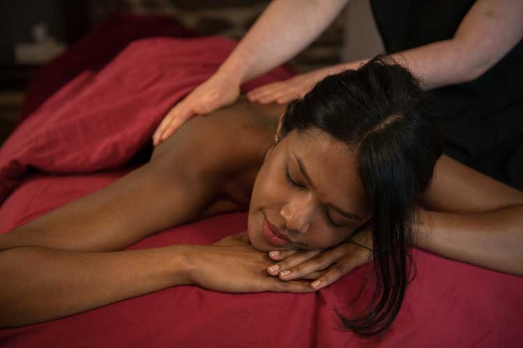 A person lying on the stomach getting Spa treatment