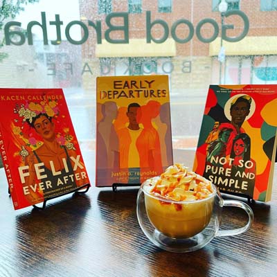 Three books placed on stand around a coffee cup