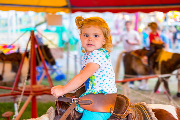 little girl sitting on horse back
