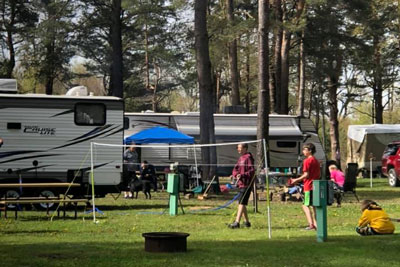 people parked RVs and  playing volley ball 