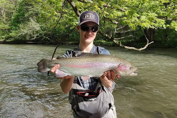 a person holding Trout fish caught