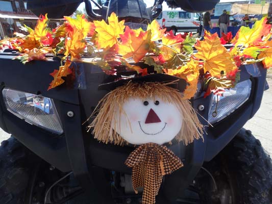 scarecrow tied infront of a vehicle