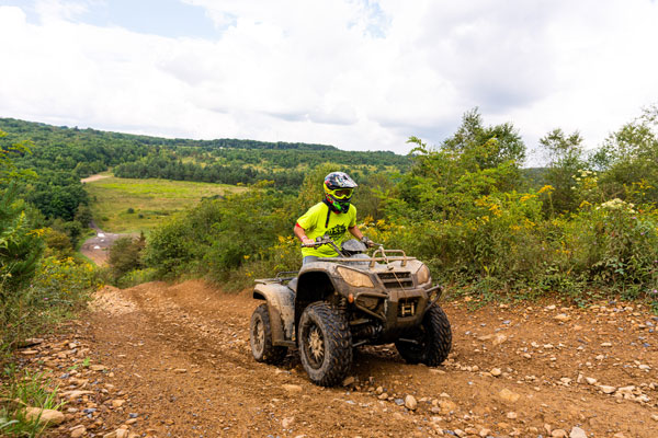 A person riding ATV thru rocky trail with Helmet on