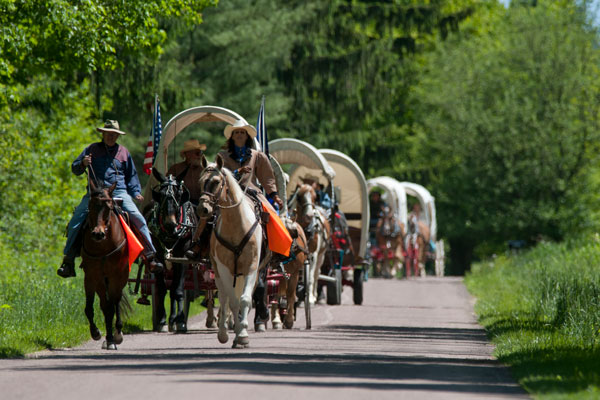 people riding on horses and horse carriage